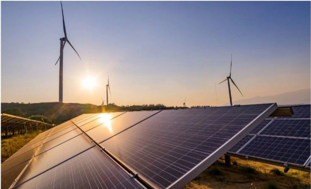 Solar panels and wind turbines at a photovoltaic power plant at sunrise